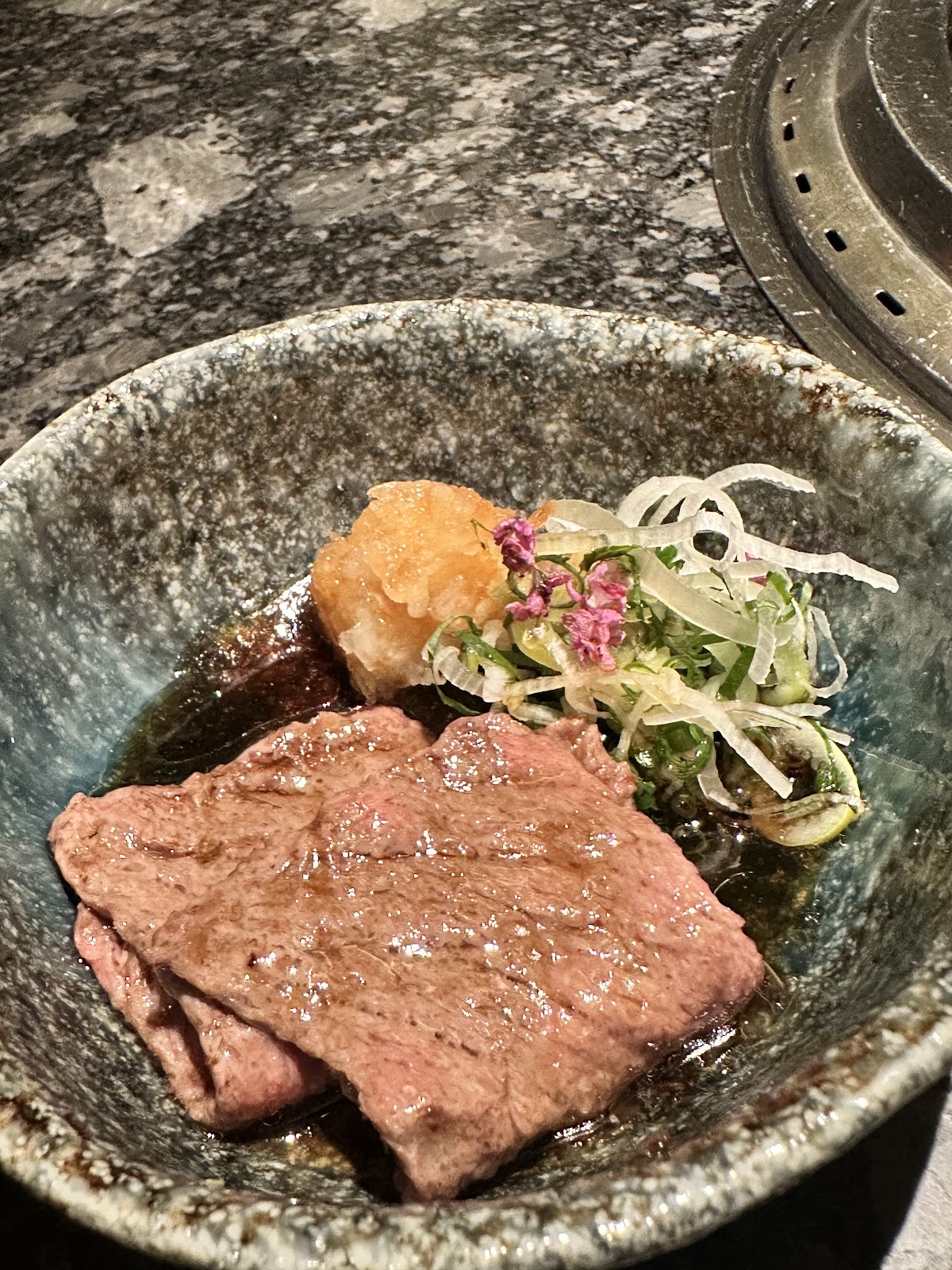 焼いた牛肉の薄切りとおろし、白髪ねぎ、小さな花。