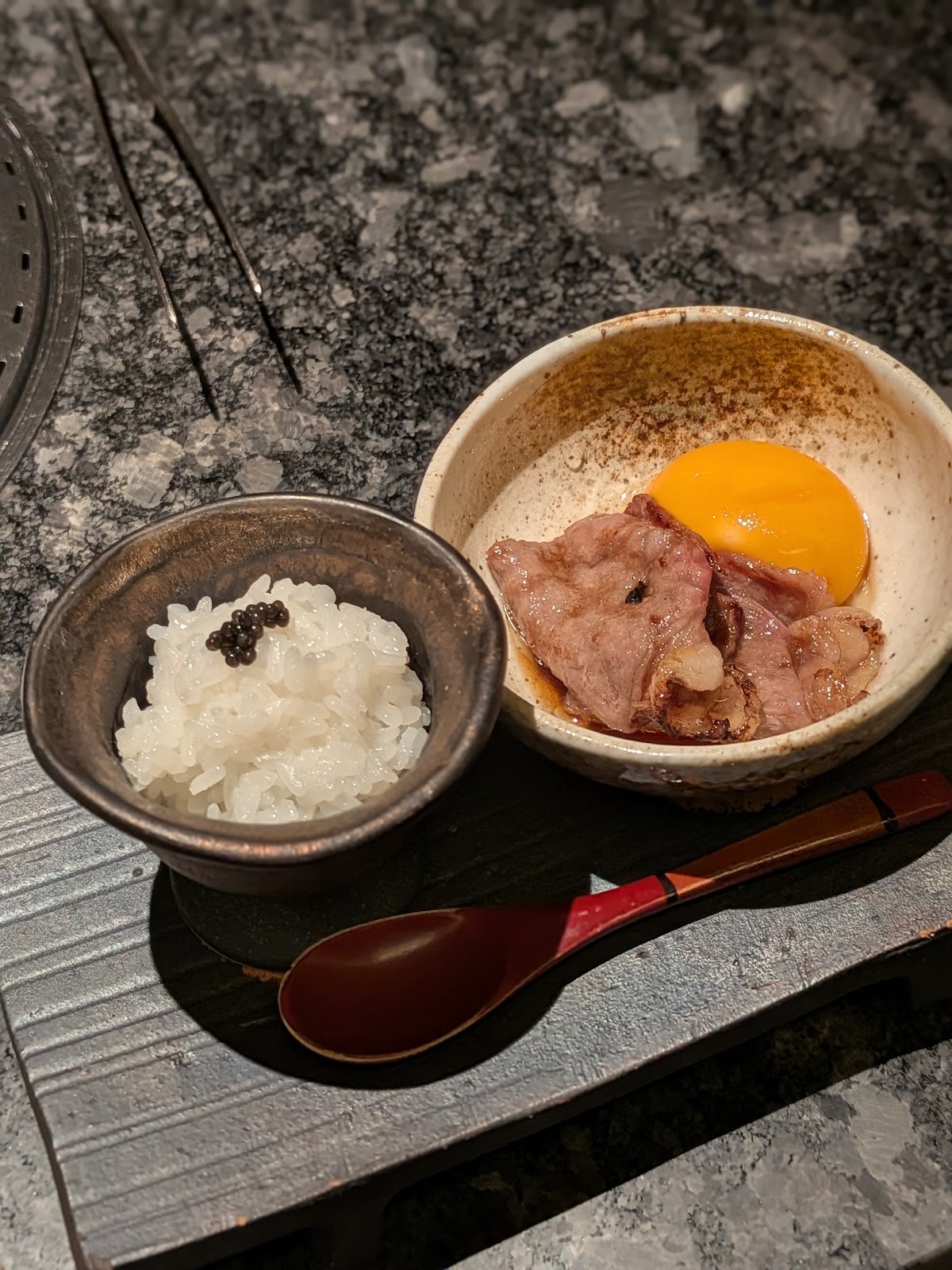 キャビアをのせたご飯の小鉢と、卵黄を添えた焼いた牛肉。