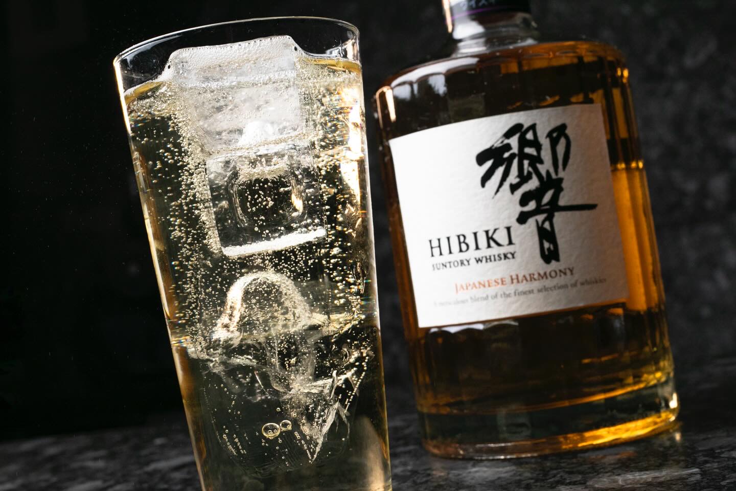 氷の入ったハイボールと、琥珀色のウイスキーのボトル。